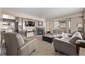 Bright and inviting living room with a cozy fireplace, plush seating, and ample natural light at 4548 E Kentucky Cir, Denver, CO 80246