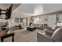 Spacious living room with large windows, neutral tones, and a comfortable seating arrangement at 4548 E Kentucky Cir, Denver, CO 80246