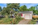 View of the home's front and garage, set among green foliage on a sunny day at 10463 Kipling Ct, Broomfield, CO 80021