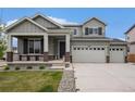 Charming two-story home with a covered porch, three-car garage and landscaped front yard at 12405 E 101St Dr, Commerce City, CO 80022