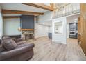Living area showcases a stone fireplace, exposed wood beams, and open layout to the kitchen at 1063 W Powers Ave, Littleton, CO 80120