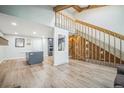 Open-concept living space with hardwood floors, stylish staircase, and seamless transition to the modern kitchen at 1063 W Powers Ave, Littleton, CO 80120