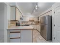 Functional kitchen features a breakfast bar, stainless steel refrigerator, and ample cabinet space at 235 S Monaco Pkwy, Denver, CO 80224