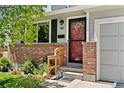 Close-up of the front entrance showcasing brick detail, a red front door, and house number at 411 S Cody Ct, Lakewood, CO 80226