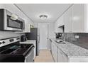 This galley kitchen features stainless appliances, granite counters, and contemporary grey backsplash at 200 N Pearl St # 106, Denver, CO 80203