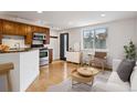 Cozy living area with open kitchen, featuring stainless steel appliances and natural light from a large window at 1 N Pearl St # 102, Denver, CO 80203