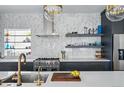 Contemporary kitchen featuring a spacious island with sink and modern appliances against a unique backsplash at 553 S Sherman St, Denver, CO 80209