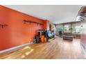 Bright living area with hardwood floors, a rustic wood accent wall, and a view of the yard at 1086 Mockingbird St, Brighton, CO 80601