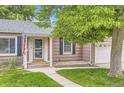 Charming home with a well-manicured lawn, complemented by trees and an inviting entryway with address number at 1697 W Powers Ave, Littleton, CO 80120