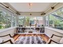 Bright sunroom with hardwood floors, built-in bookshelves, large windows overlooking the backyard, and stylish décor at 1697 W Powers Ave, Littleton, CO 80120