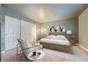 Spacious bedroom with double doors and a sitting chair at 6702 S Ivy Way # A1, Centennial, CO 80112