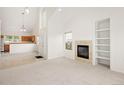 Open concept living space with fireplace, custom shelves, and view to the kitchen at 15555 E 40Th Ave # 36, Denver, CO 80239