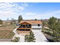 Beautiful home featuring a spacious two-car garage and covered deck, under a clear blue sky at 3303 Wolfensberger Rd, Sedalia, CO 80135