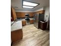 Well-lit kitchen with stainless steel appliances, wooden cabinets, and tiled floor at 3923 S Idalia St, Aurora, CO 80013