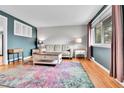 Cozy living room with hardwood floors, complemented by a colorful rug and natural light from a window at 4680 Independence St, Wheat Ridge, CO 80033