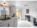 Well-lit kitchen with white cabinets, stainless steel sink, and sliding glass door at 12993 W 20Th Ave, Golden, CO 80401