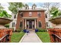 Elegant brick facade with manicured lawn and decorative planters, showcasing a beautiful property at 1332 S Lafayette St, Denver, CO 80210