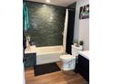 Clean bathroom with dark green tile and a bathtub at 3736 S Lincoln St, Englewood, CO 80113