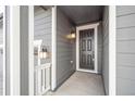 Front entry with gray siding, a dark door, and white trim at 1546 Farmstead St, Brighton, CO 80601