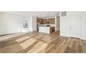 Open living room with hardwood floors and kitchen island at 1546 Farmstead St, Brighton, CO 80601