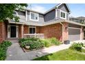 Charming two-story brick home with gray siding, manicured front yard and a two-car garage at 5795 S Pagosa Way, Centennial, CO 80015