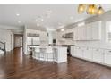 Spacious gourmet kitchen with white cabinetry, stainless appliances and large island with seating at 16227 Pikes Peak Dr, Broomfield, CO 80023