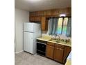 A kitchen featuring wood cabinets, neutral countertops, and a white refrigerator at 9062 Utica St, Westminster, CO 80031