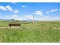 Scenic view of community green space featuring a bench, trail, and distant mountain views at 10723 N Montane Dr, Broomfield, CO 80021