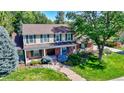 Charming two-story home with manicured lawn, mature trees, and inviting front porch creating curb appeal at 3850 S Willow Way, Denver, CO 80237