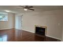 Bright living room featuring hardwood floors, a ceiling fan, and a cozy fireplace at 12450 E Cornell Ave # 101, Aurora, CO 80014