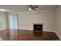 Living room with hardwood floors, fan and a fireplace at 12450 E Cornell Ave # 101, Aurora, CO 80014