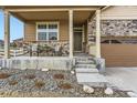 Welcoming front porch with seating and stylish stone accents, highlighting the home's entrance at 6045 High Timber Cir, Castle Rock, CO 80104