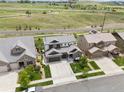 An aerial view of a house with neutral colors, a driveway, and green grass surrounding the home at 3056 Yale Dr, Broomfield, CO 80023