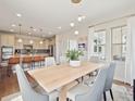 Sunlit dining area with elegant table, chairs, and modern pendant lighting adjacent to the kitchen at 3056 Yale Dr, Broomfield, CO 80023