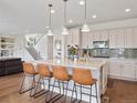 Bright kitchen with modern appliances, granite counters, large island, and stylish pendant lighting at 3056 Yale Dr, Broomfield, CO 80023
