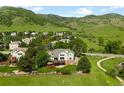 Areal rear view of a residence featuring a deck, manicured lawn, and a fence at 50 Deerwood Dr, Littleton, CO 80127