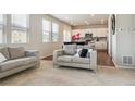 Bright living room with neutral decor, an open floor plan, and views to the kitchen at 6491 N Danube St, Denver, CO 80249