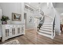 Grand foyer with curved staircase, light wood floors, and elegant decor at 5207 Denim Ct, Parker, CO 80134