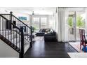 Bright living room with dark hardwood floors, a corner fireplace, large windows, and access to an outdoor patio at 500 176Th Ave, Broomfield, CO 80023