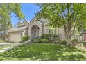 Beautiful brick home featuring lush landscaping and an inviting arched entryway at 85 Silver Fox Dr, Greenwood Village, CO 80121