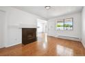 Bright living room with hardwood floors, a cozy fireplace, and large windows offering ample natural light at 6007 Yarrow St # I, Arvada, CO 80004