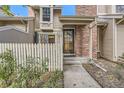 Welcoming townhome featuring a fenced entry, brick chimney, and well-maintained landscaping at 14193 E Radcliff Cir, Aurora, CO 80015