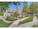 Charming townhome exterior with brick chimney, lush landscaping, and a picturesque setting at 14193 E Radcliff Cir, Aurora, CO 80015