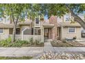 Inviting townhome exterior with a brick chimney, a fenced entrance, and a landscaped walkway at 14193 E Radcliff Cir, Aurora, CO 80015