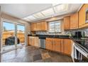 Bright kitchen with wood cabinets, tile floor, and sliding glass door at 14204 E Baltic Cir, Aurora, CO 80014