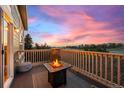 Relaxing balcony with a fire pit, outdoor seating, and views of the sunset at 24547 E Easter Pl, Aurora, CO 80016