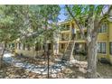 Charming condo exterior featuring an outdoor seating area and natural landscaping with mature trees at 980 S Dahlia St # F, Denver, CO 80246