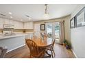 Bright dining area with wood table set with flower centerpiece and a sliding door to the outside at 5786 Biscay St, Denver, CO 80249