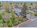 Aerial view of a charming home featuring a well-manicured yard, a lush garden and mature trees at 3201 S Clarkson St, Englewood, CO 80113