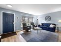 Comfortable living room with hardwood floors, large window and stylish blue accent wall and decor at 7272 E Appleton Cir, Centennial, CO 80112